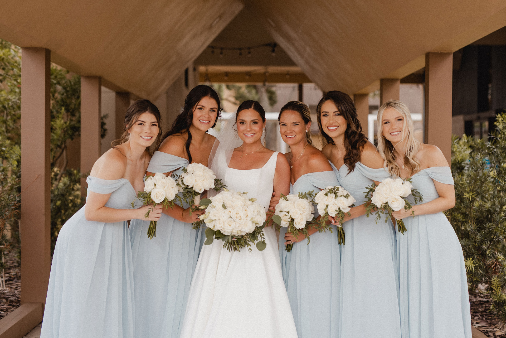 Bridesmaids in soft blue with white bouquets